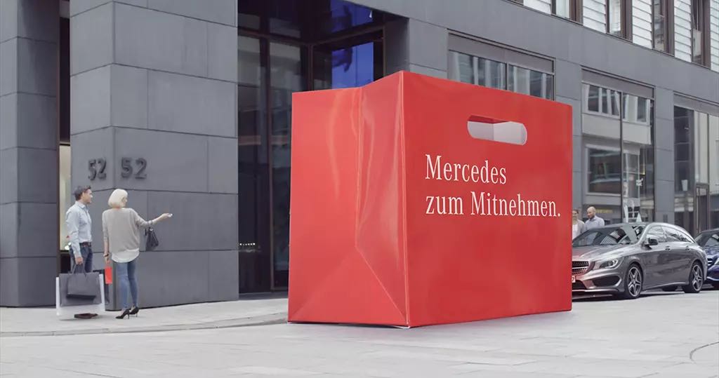 Mercedes-Benz Werbespot: rote Einkaufstasche vor einem Mercedes in der Stadt